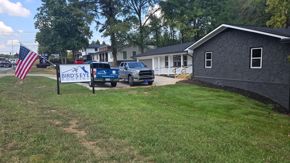 Bird's Eye Roofing truck and yard sign at a completed Roswell project